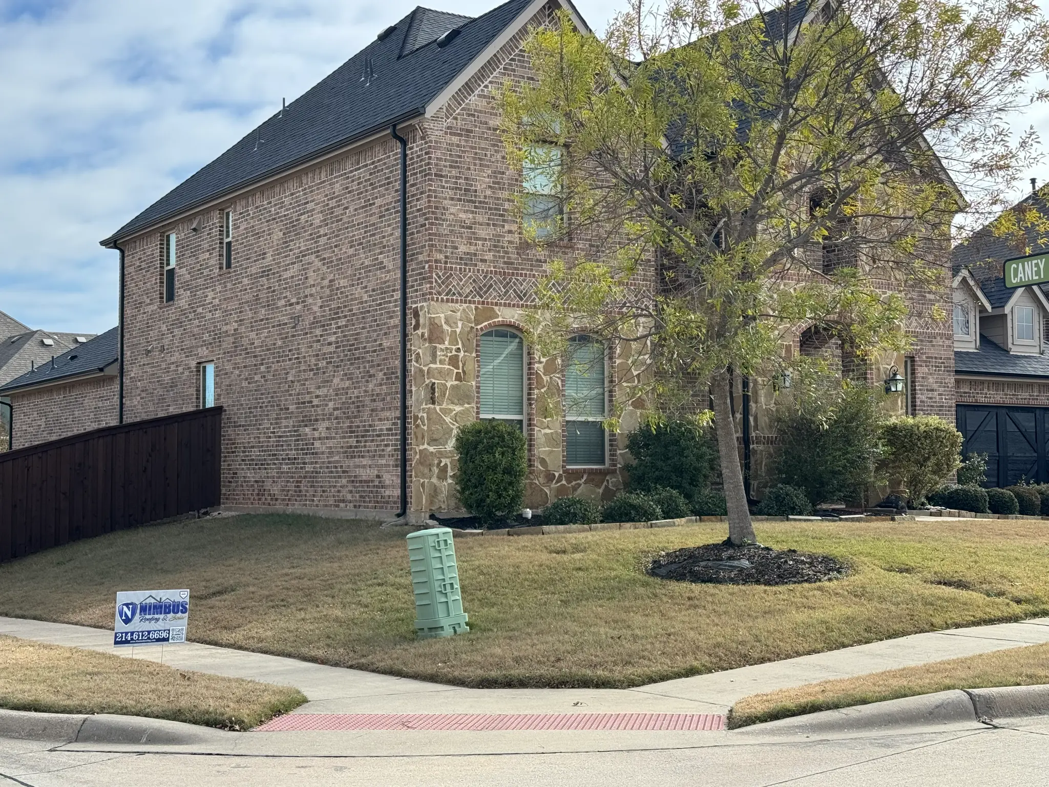 Completed two-story residential roof with Nimbus yard sign - Professional craftsmanship