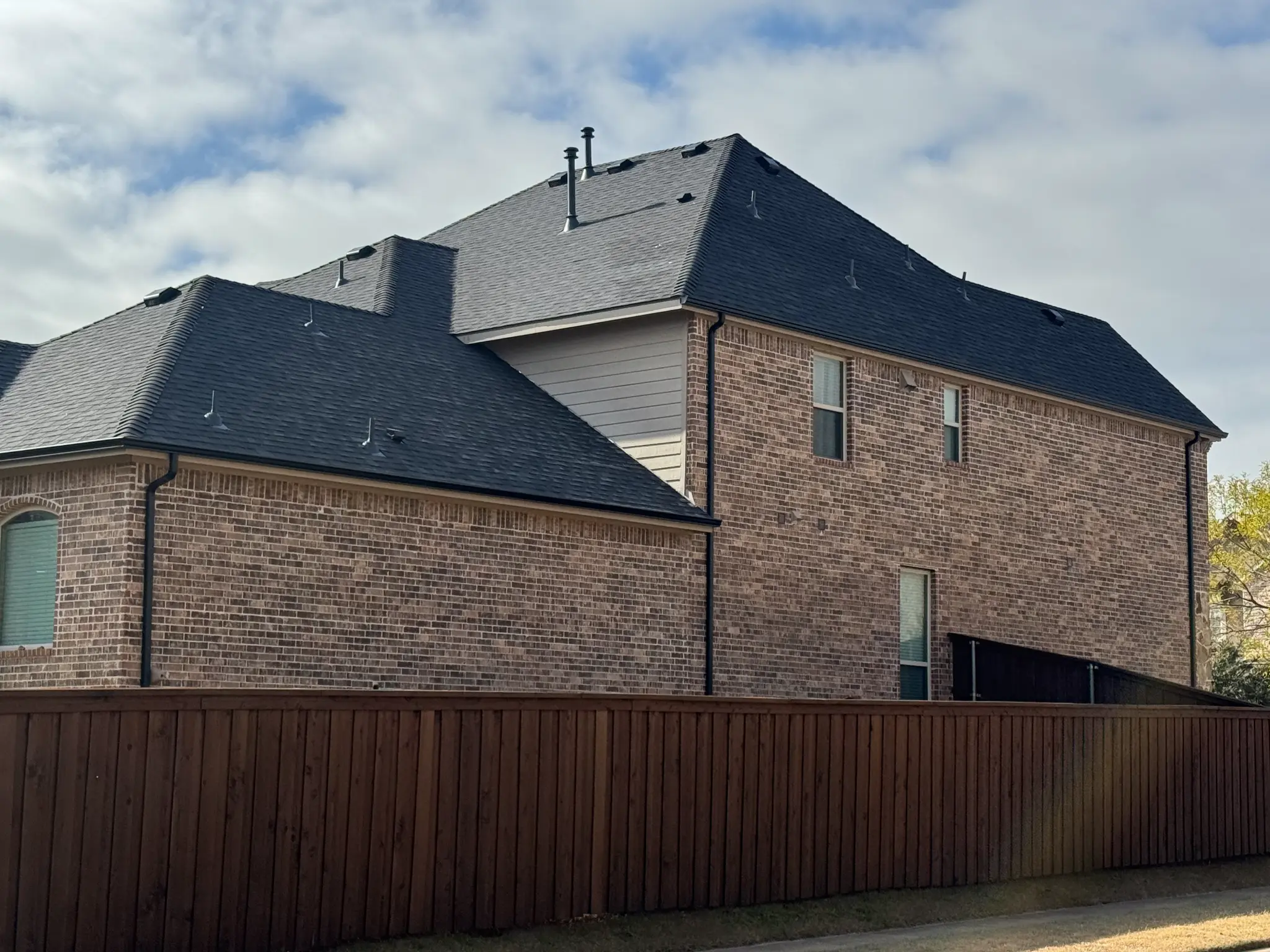 Completed residential roof with dark shingles - Modern architectural design